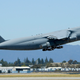 The C-5 containing 32 tons of satellite and equipment takes off at Moffett Field.